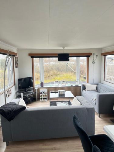 a living room with a couch and a table at Chalet Inn Ameland inclusief Fietsen, Zee en Strand op loopafstand! in Buren