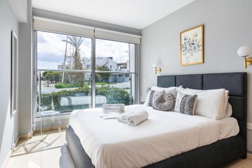 a bedroom with a large bed and a large window at 1BR Apt. next to Coralli Beach Protaras in Paralimni