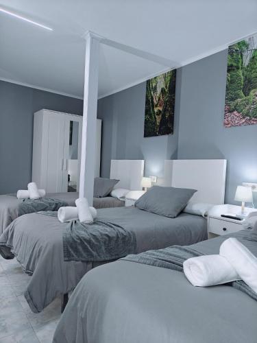 three beds in a room with blue walls at Casa de Fernando in Treacastela