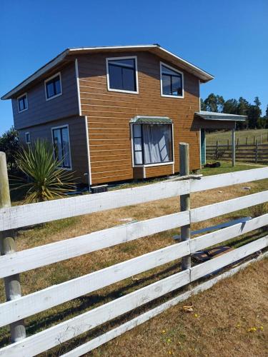 a house with a fence in front of it at Casa grande el dao in Calbuco