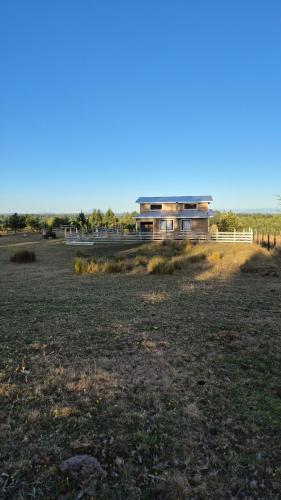 a house in the middle of a field at Casa grande el dao in Calbuco