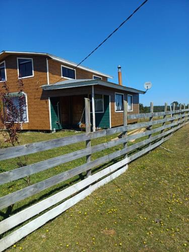 a wooden fence in front of a house at Casa grande el dao in Calbuco