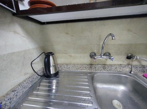 a tea kettle sitting on top of a kitchen sink at comfort stay 1 in Al Ain