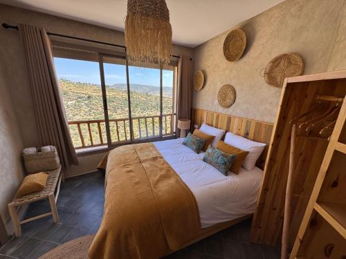 a bedroom with a bed and a large window at Manapany Surf Camp in Tamraght Ouzdar
