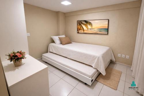 a small bedroom with a bed and a table at Palm Beach 206 BL 4 by Holiday Stays in Aquiraz