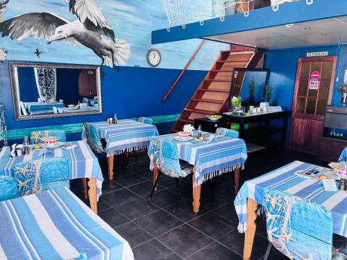 a restaurant with blue and white tables and a staircase at Cape Nomads in Muizenberg
