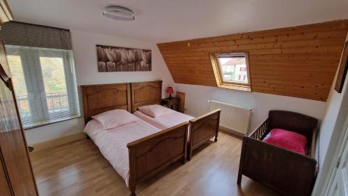 a bedroom with a bed and two chairs in it at Gîte Eugénie in Aspach-le-Bas