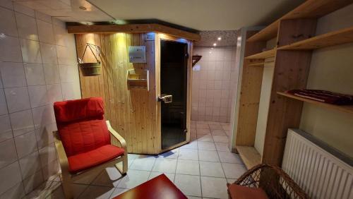 a bathroom with a red chair and a door at Gîte Eugénie in Aspach-le-Bas