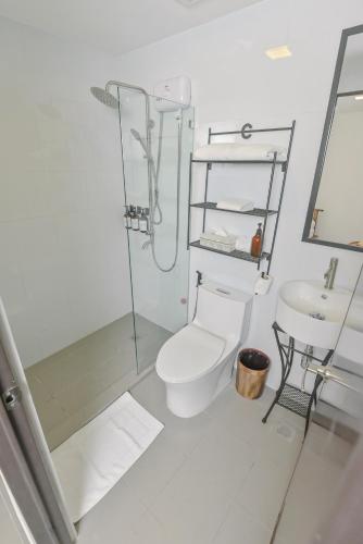 a bathroom with a shower and a toilet and a sink at Casa Charlie Hotel in Manila