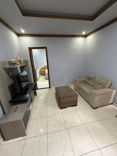 a living room with a couch and a television at Casa Ibirapuera in Vitória da Conquista