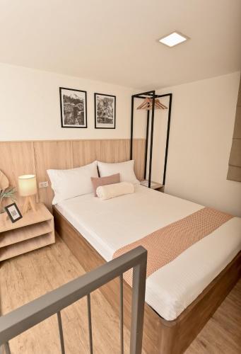 a bedroom with a large bed with white sheets at Casa Charlie Hotel in Manila