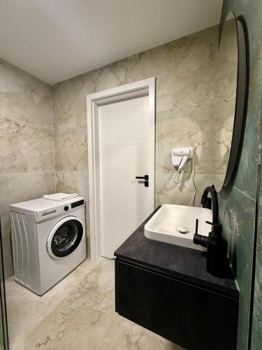 a bathroom with a washing machine and a sink at Drahan Apartment 38 in Radom