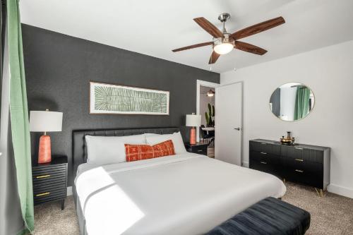 a bedroom with a white bed and a black wall at The Orange Door - Two Homes - Plunge Pool in Austin
