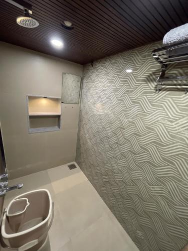 a bathroom with a toilet and a wall at Myra Villa Kolhapur Entire Private Home in Kolhapur