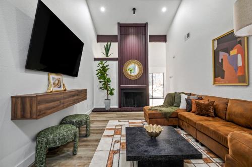 a living room with a couch and a tv at The Orange Door - Unit A - Heated Plunge Pool in Austin