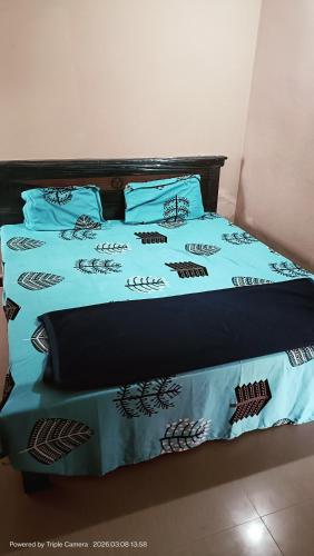 a bed with blue and black sheets and pillows at Durga Nivas in Kurnool