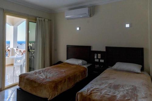 a hotel room with two beds and a balcony at sharks bay oasis aqua park in Sharm El Sheikh