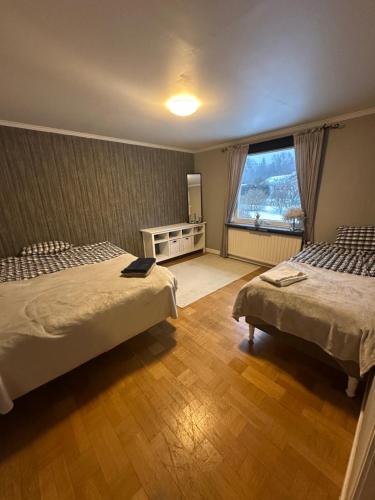 a bedroom with two beds and a large window at Charmigt hus uthyres in Holsljunga