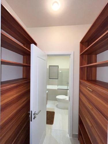 a bathroom with wooden doors and a toilet at Sky Garden Appartement in Quatre Bornes