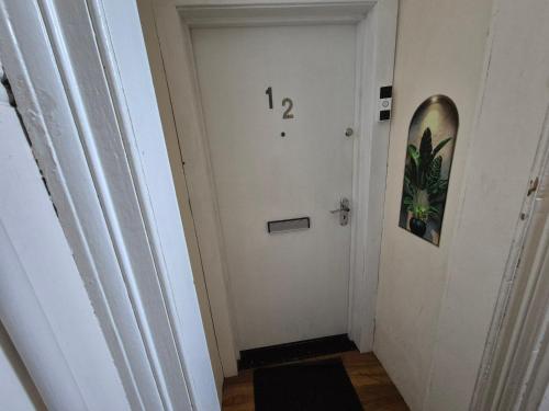 a hallway with a door with a number on it at Cosy and Bright 3-bedroom flat in Glasgow