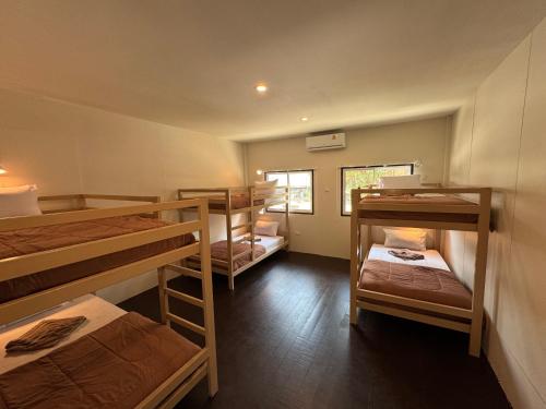 a room with four bunk beds and a window at Lazy Garden Hostel in Phra Ae beach