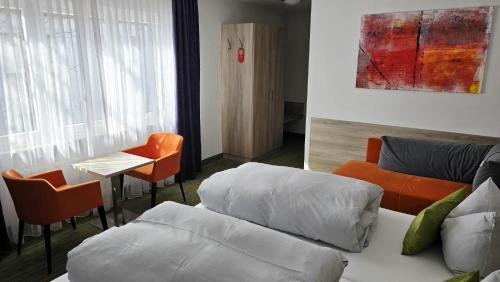a room with a bed and a table and a couch at Gästehaus König in Weinstadt