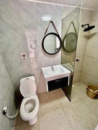 a bathroom with a toilet and a sink and a mirror at Glamping Calla in Banjarnegara