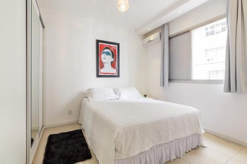 Un dormitorio blanco con una cama y una ventana. en Apartamento Floripa, en Florianópolis