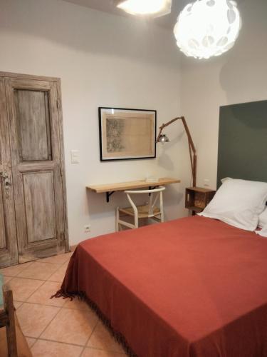 a bedroom with a bed and a desk and a lamp at La Maison De Stephanie in Porto-Vecchio