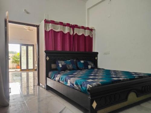 a bedroom with a bed with a red curtain at SRI PADMAVATHI NiVAS in Pithāpuram