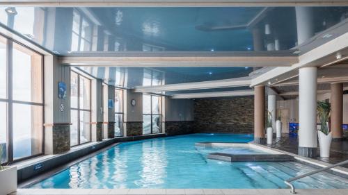 a large swimming pool in a building with windows at Résidence Pierre & Vacances Premium L'Amara in Avoriaz