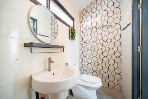 a bathroom with a sink and a mirror and a toilet at NO 7 Garden Villa in Rawai Beach