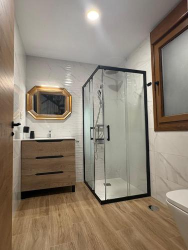 a bathroom with a glass shower and a sink at Apartamentos Rurales Sariar in Villar