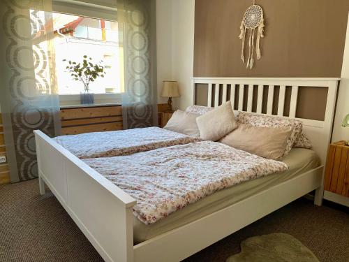 a bedroom with a large white bed with a window at Ferienwohnung Zum Preußensteig I max 3 Gäste in Pfeffelbach