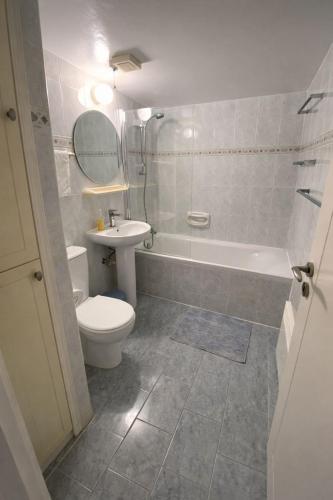 a bathroom with a toilet and a tub and a sink at Two BR Sea View with Balcony and Pool Paphos in Khlorakas