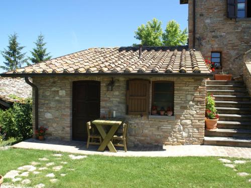 a small stone house with a table in the yard at Holiday Home in Montone with Pool & Terrace in Montone