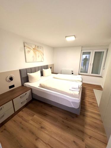 a bedroom with a large bed and a wooden floor at Apartments Rosenstraße in Soltau