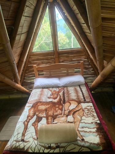 a bed in a room with a painting on it at Cabaña Dos Búhos in Murillo