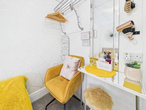 a room with a yellow chair and a desk at Sorrento House in Blackpool