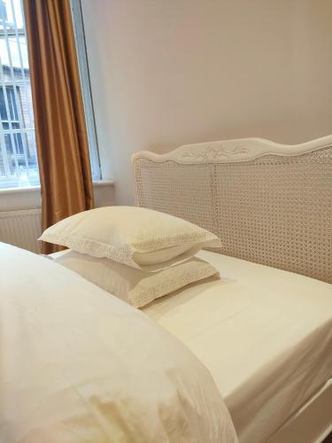 a bed with white sheets and pillows next to a window at Venice in Nottingham