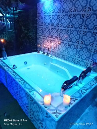 a bath tub with two candles in a bathroom at Finca San Miguel Filandia in Filandia