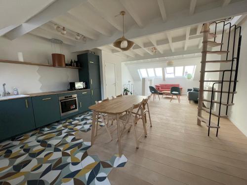 a kitchen and dining room with a table and chairs at Triplex de charme avec vue in Brussels