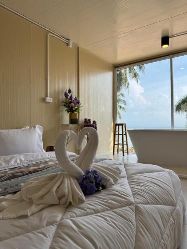 a bed with two heart shaped towels on it at Sand Bara in Ban Pak Ba Ra