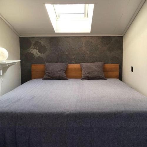 a bedroom with a large bed with a skylight at Dat Witte Huuske in Emden