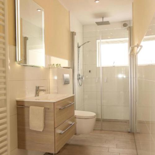 a bathroom with a sink and a toilet and a shower at Dat Witte Huuske in Emden
