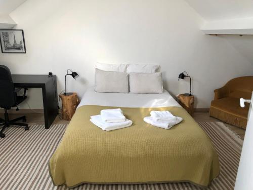a bedroom with a bed with two towels on it at 10 Courchamp in Courchamp