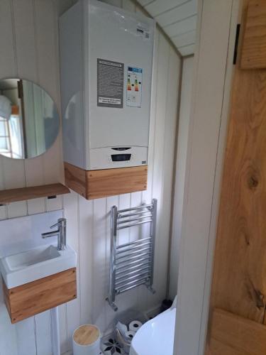a small bathroom with a sink and a microwave at Trouble House in Tetbury
