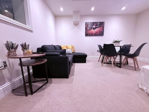 a living room with a couch and a table at Family,Cosy 2 Bedroom Apartment with Garden Close to Town, Seafront, Hospital, Free Parking in Eastbourne