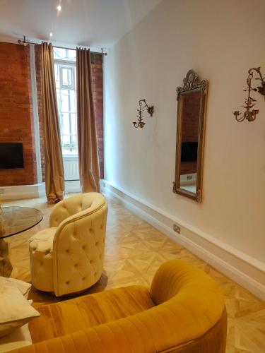 a living room with a yellow couch and a mirror at Venice in Nottingham