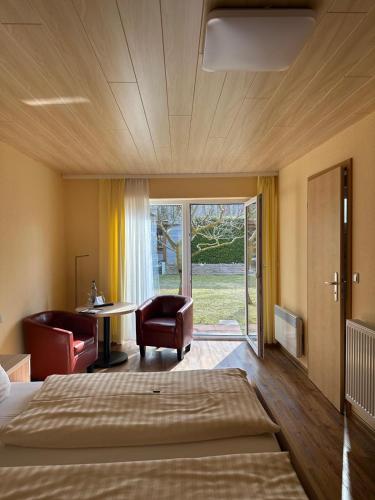 a bedroom with a bed and a desk and chairs at Pension Buchfink in Ueckeritz